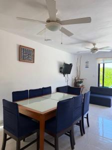 a dining room with a table and blue chairs at Casa Nora in Sisal +21 photos