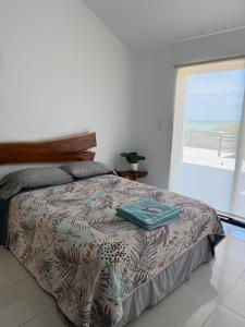 a bedroom with a bed with a view of the ocean at Casa Nora in Sisal