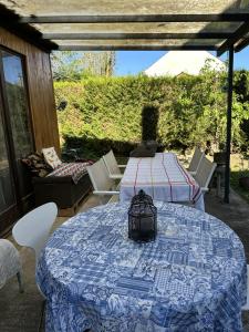 a table with a blue and white blanket on a patio at Le Chalet de Marie France in Combs-la-Ville