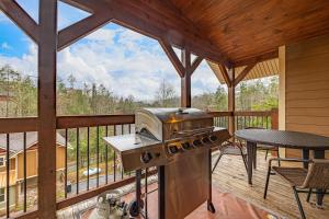 a grill on a deck with a table and a table at Hilltop Haven in Gatlinburg