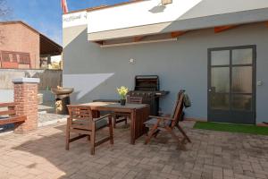 a patio with a table and chairs and a grill at Lore Sole in Caluso
