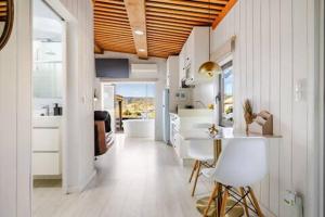 a kitchen with white cabinets and a table and chairs at Mar no Camiño. Terraza, bañera con vista al mar. in Brens