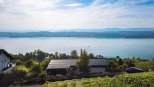 a view of a lake with a house with solar panels at Studio with panoramic view in Bellerive