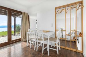 a dining room with a white table and chairs at Studio with panoramic view in Bellerive +15 photos