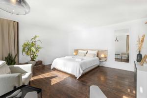 a white bedroom with a bed and a couch at Studio with panoramic view in Bellerive