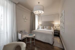 ein Schlafzimmer mit einem Bett, einem Tisch und einem Stuhl in der Unterkunft Bastion Heritage Hotel in Zadar + 113 Fotos