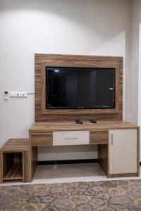 a flat screen tv sitting on top of a wooden entertainment center at شقــق فندقيـة in Hail +4 photos