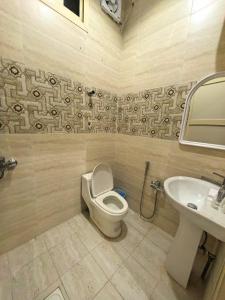 a bathroom with a toilet and a sink at شقــق فندقيـة in Hail