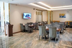 a restaurant with tables and chairs and a tv on the wall at فندق ليان بارك Lian Park Hotel in Al Khobar +199 photos