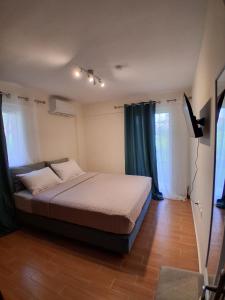 a bedroom with a bed and two windows at Οcalia Apartment in Petrokhórion