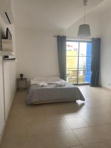 a bedroom with a bed and a large window at Porta 28 in Quinta do Anjo