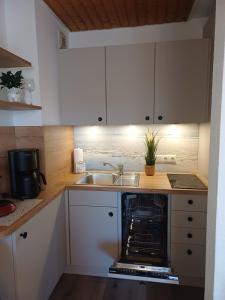 a kitchen with a sink and an oven at Sielpferdchen Bensersiel in Bensersiel +26 photos