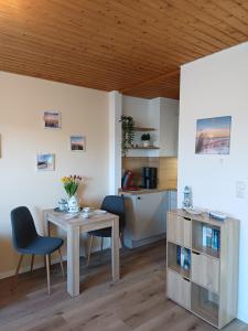 a living room with a table and a kitchen at Sielpferdchen Bensersiel in Bensersiel