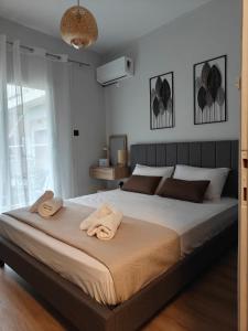 a bedroom with a large bed with towels on it at house blue sea in Iraklitsa