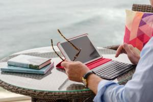 two people sitting at a table with a laptop computer at In Tenerife, luxury apartment overlooking the Atlantic in Bajamar