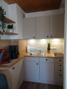 a kitchen with white cabinets and a sink at Sielpferdchen Bensersiel in Bensersiel