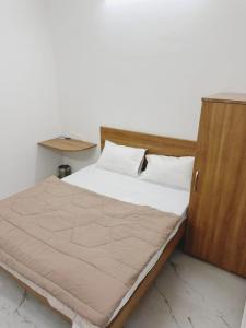 a bedroom with a bed with a wooden headboard at Hotel Aura Avenue in Bathinda