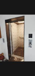 a small bathroom with a door into a room at Hotel Aura Avenue in Bathinda