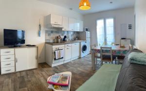 a living room with a kitchen and a dining room at Le sable chaud in Saint-Pierre-dʼOléron