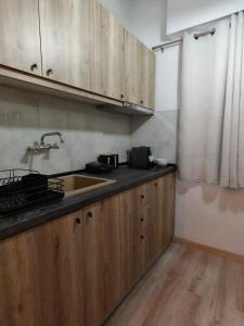 a kitchen with wooden cabinets and a sink at house blue sea in Iraklitsa +15 photos