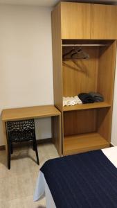 a bedroom with a wooden cabinet and a desk and a bed at Casa da Dinda 104 in Rio das Ostras