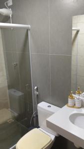 a bathroom with a shower and a toilet and a sink at Casa da Dinda 104 in Rio das Ostras