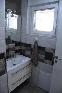 a bathroom with a sink and a window at Prestige in Šabac +1 photo