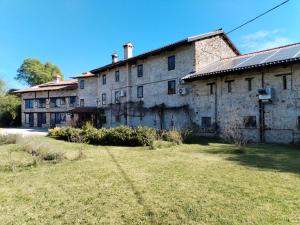 ein altes Steingebäude mit einem Hof davor in der Unterkunft Al Rol in Manzano