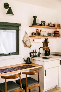 a kitchen with a sink and a counter with two chairs at A-Frame Cliffside Studio Cabins in South Fork