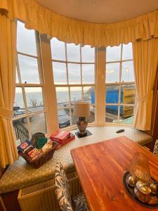 a living room with a table and a large window at Haddock Hideaway at The Whiteley in Scarborough