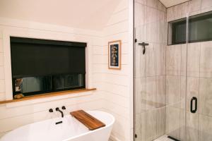 a bathroom with a tub and a shower and a sink at A-Frame Cliffside Studio Cabins in South Fork +22 photos