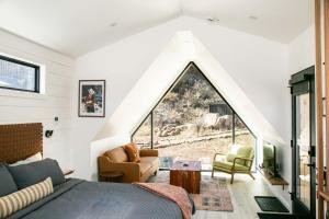 a bedroom with a large window and a bed at A-Frame Cliffside Studio Cabins in South Fork