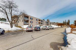 a street with cars parked in front of a building at Lakeside Delight, unit 423 in Laconia