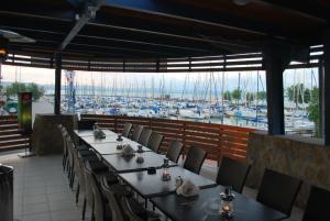 a restaurant with tables and chairs and a marina at Sekli Panzió in Balatonlelle