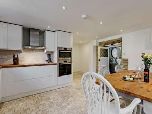 a kitchen with a wooden table and white cabinets at 3 Bed in Witney oc-82478 in Hailey