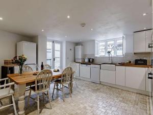 a kitchen with a wooden table and a table and chairs at 3 Bed in Witney oc-82478 in Hailey +10 photos