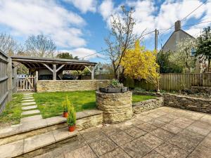 a backyard with a stone retaining wall and a fence at 3 Bed in Witney oc-82478 in Hailey