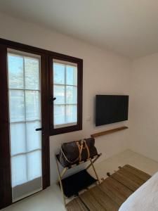 a room with a bed and a television and a chair at Villa Vittoria in Lignano Sabbiadoro