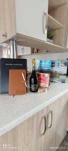 a bottle of whiskey sitting on a counter with books at Dulce Casa 34 2 bedroom with hot tub in Grantown on Spey