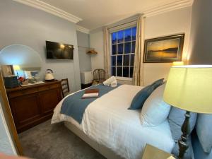 a bedroom with a bed and a desk and a window at Haddock Hideaway at The Whiteley in Scarborough