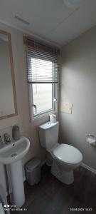 a bathroom with a white toilet and a sink at Dulce Casa 34 2 bedroom with hot tub in Grantown on Spey