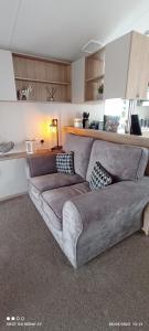 a living room with a couch in a room at Dulce Casa 34 2 bedroom with hot tub in Grantown on Spey +22 photos