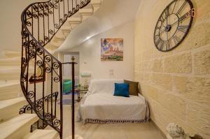 a bedroom with a bed and a large clock on the wall at Suite Victory Authentic Maltese Duplex in Birgu in Birgu