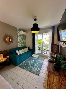 a living room with a blue couch and a window at PARADISIAC LAGOON in Saint-François +22 photos