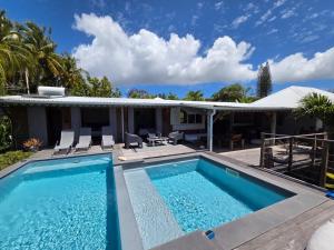 a swimming pool in front of a house at Makiese Resort in Saint-François