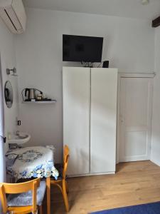 a room with a white cabinet with a television on top at Guest house Adonis in Bruges