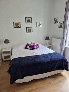 a bedroom with a bed with a blue blanket on it at Guest house Adonis in Bruges