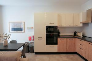 a kitchen with white cabinets and a black appliance at Tan-Nanna by Shmoo, Sliema Ferries in Sliema