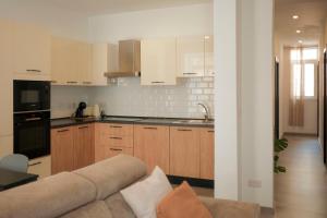 a living room with a couch and a kitchen at Tan-Nanna by Shmoo, Sliema Ferries in Sliema