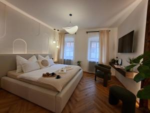 a bedroom with a large white bed and a desk at Old Town Living Studio in Český Krumlov